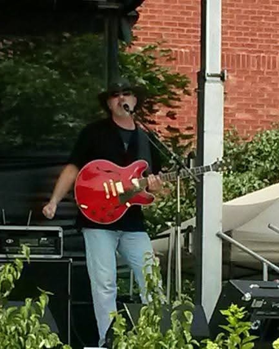 Mark McKechnie singing on stage with electric guitar